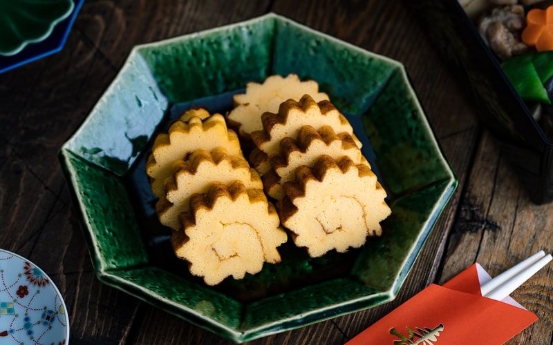 A green plate containing Datemaki, Japanese sweet rolled omelette, enjoyed during the New Years.