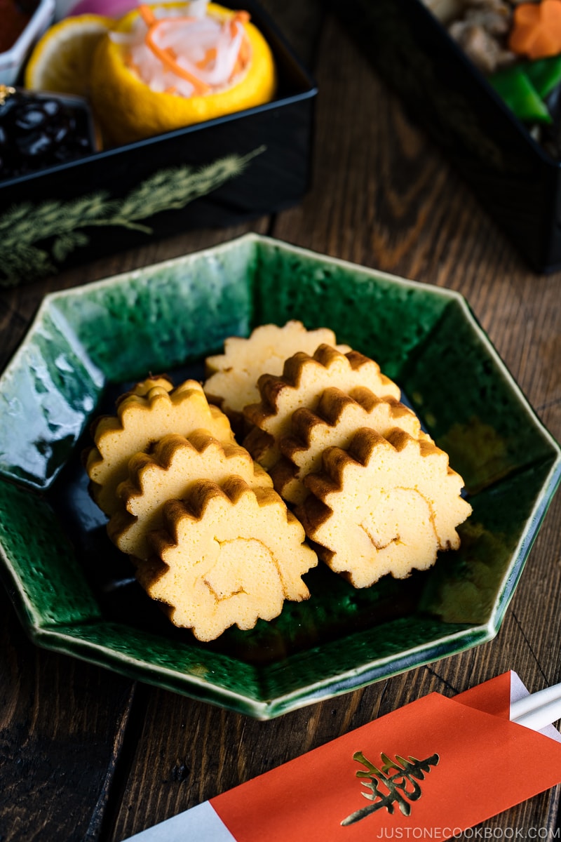 A green plate containing Datemaki, Japanese sweet rolled omelette, enjoyed during the New Years.