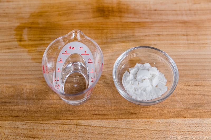 cornstarch in a bowl next to 2 tbsp of water