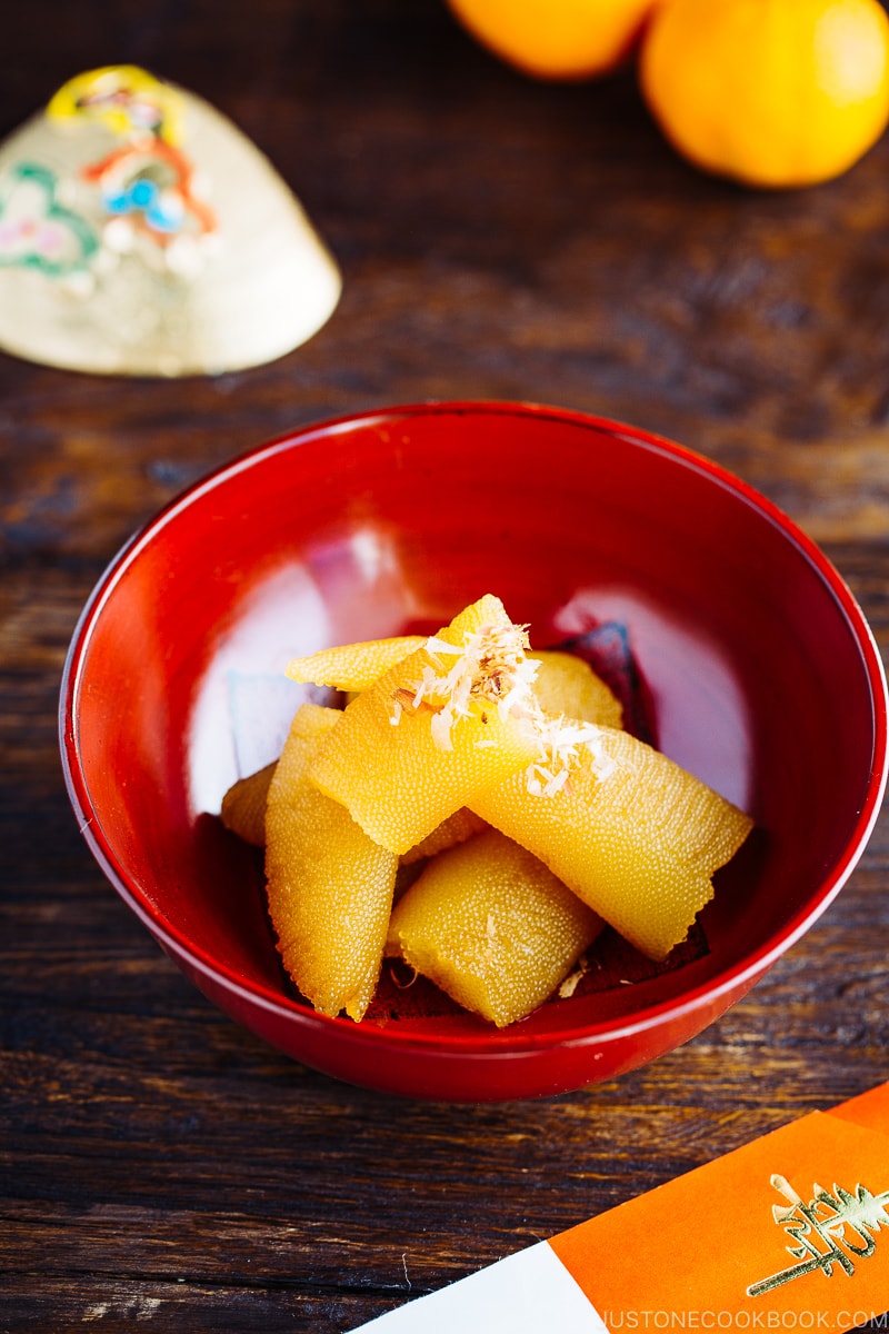 A red lacquered bowl containing Kazunoko (Herring Roe) topped with katsuobushi.