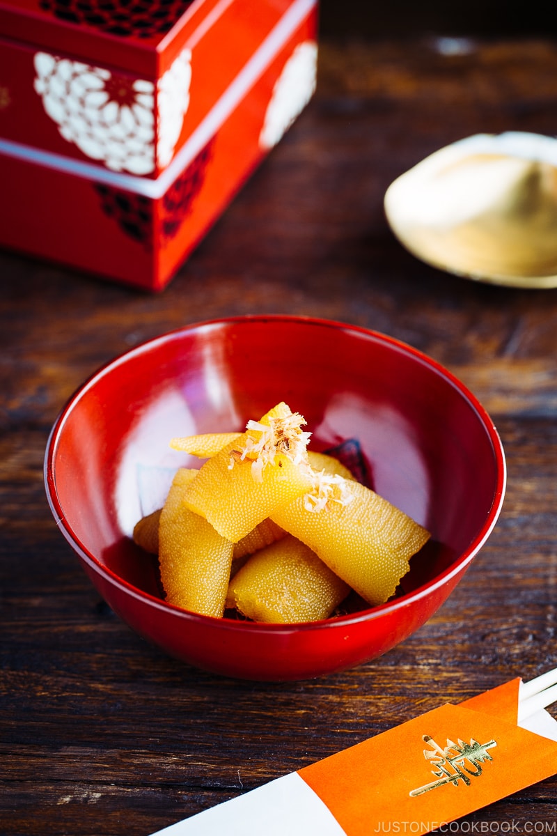 A red lacquered bowl containing Kazunoko (Herring Roe) topped with katsuobushi.