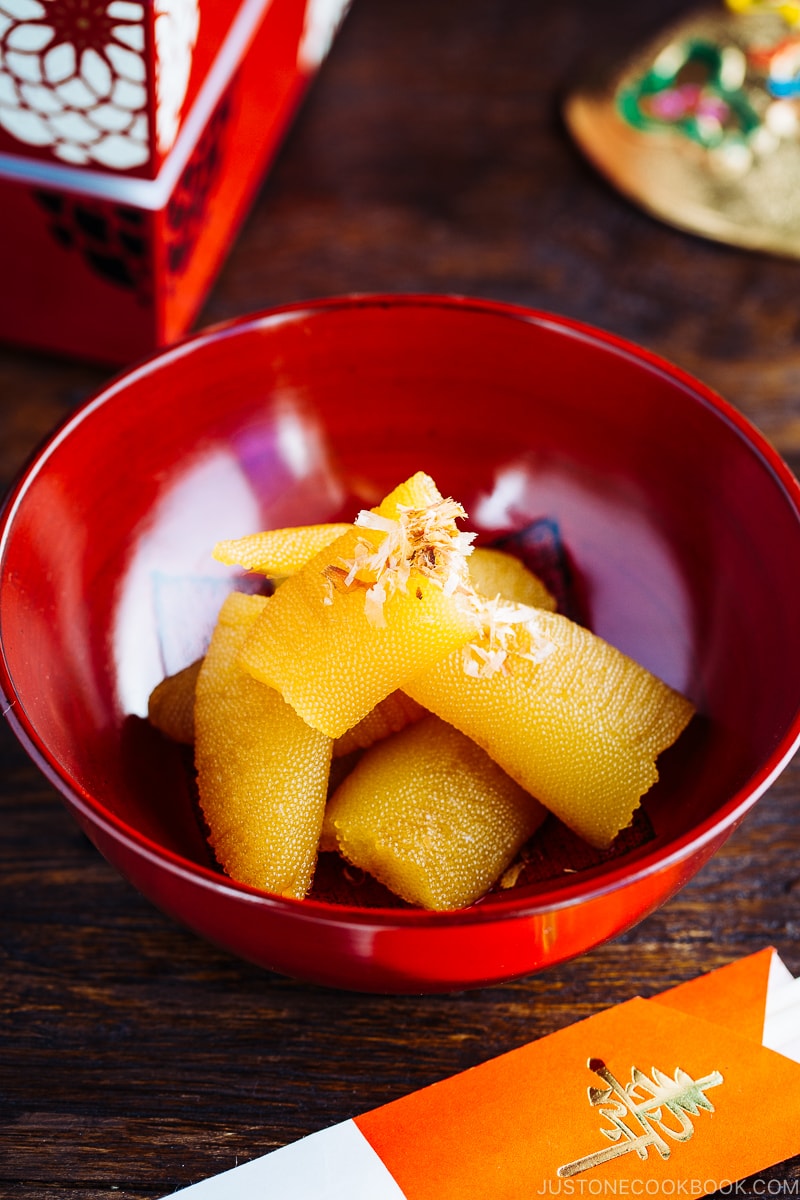 A red lacquered bowl containing Kazunoko (Herring Roe) topped with katsuobushi.