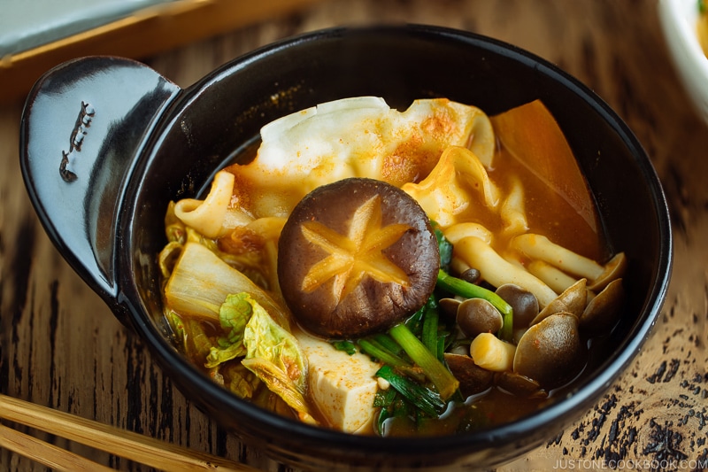 A donabe hot pot containing kimchi gyoza hot pot stew.