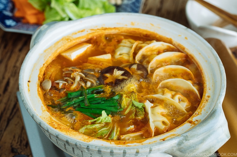 A donabe hot pot containing kimchi gyoza hot pot stew.