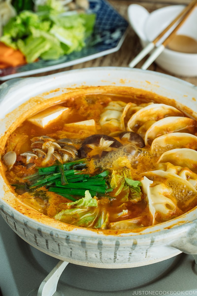 A donabe hot pot containing kimchi gyoza hot pot stew.