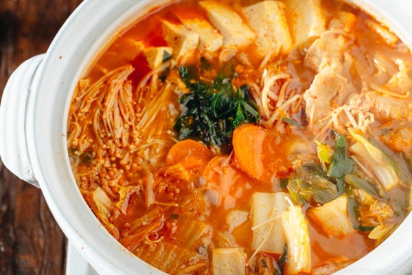 A Japanese donabe containing kimchi stew filled with vegetables and kimchi.