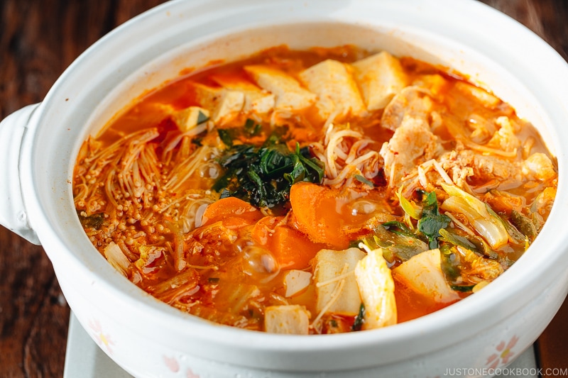 A Japanese donabe containing kimchi stew filled with vegetables and kimchi.