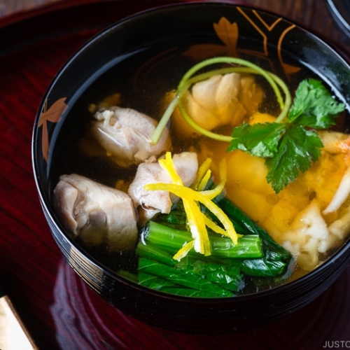 A black and gold lacquered bowl containing Japanese New Year Soup Ozoni.