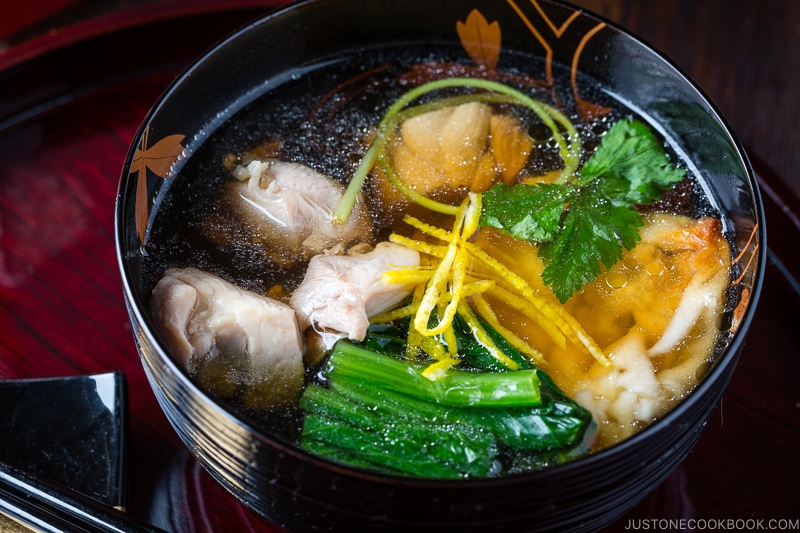 A black and gold lacquered bowl containing Japanese New Year Soup Ozoni.
