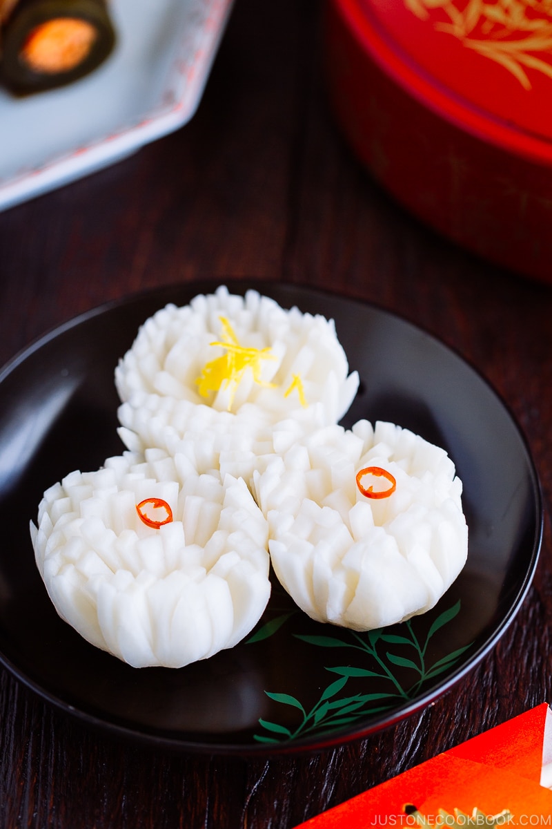 A black lacquered plate containing Pickled Chrysanthemum Turnip (Kikka Kabu).