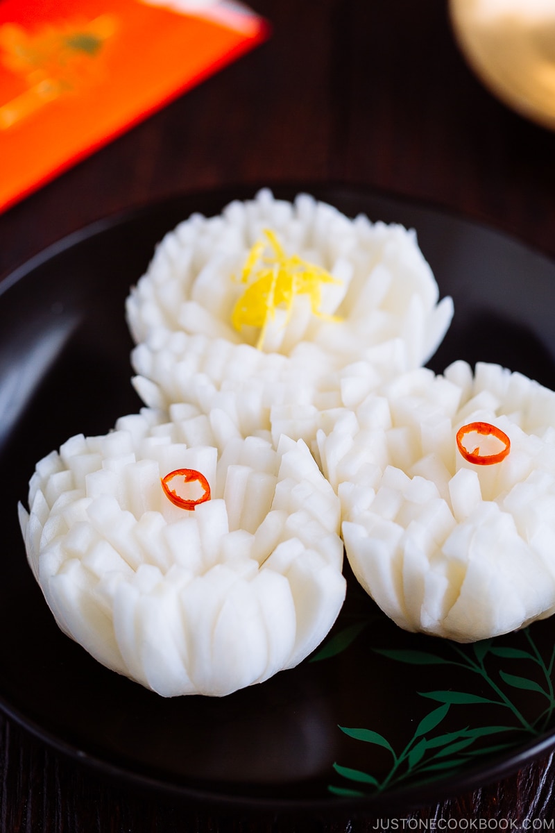 A black lacquered plate containing Pickled Chrysanthemum Turnip (Kikka Kabu).