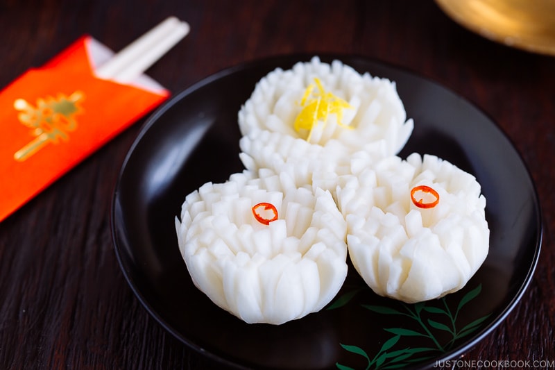 A black lacquered plate containing Pickled Chrysanthemum Turnip (Kikka Kabu).