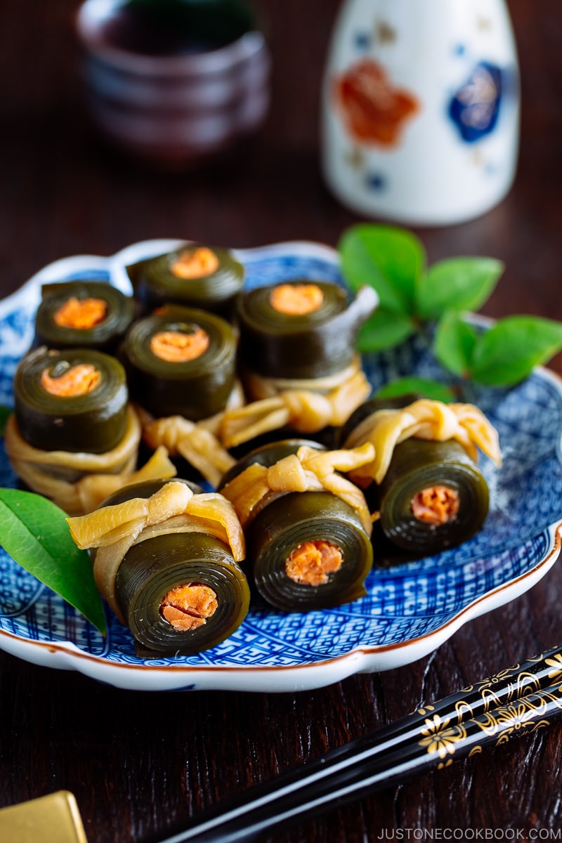 A blue Japanese plate containing salmon kombu rolls.