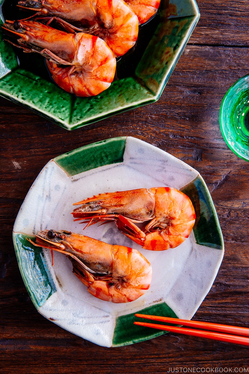 Green and white ceramic containing Simmered shrimp.