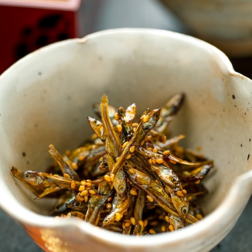 White flower-shaped ceramic containing candied sardines (tazukuri)