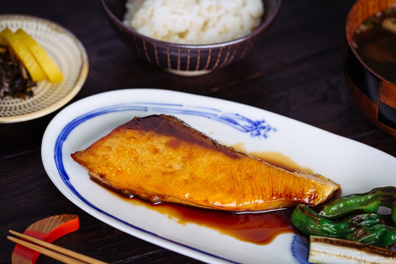 Yellowtail teriyaki served with blistered shishito peppers.