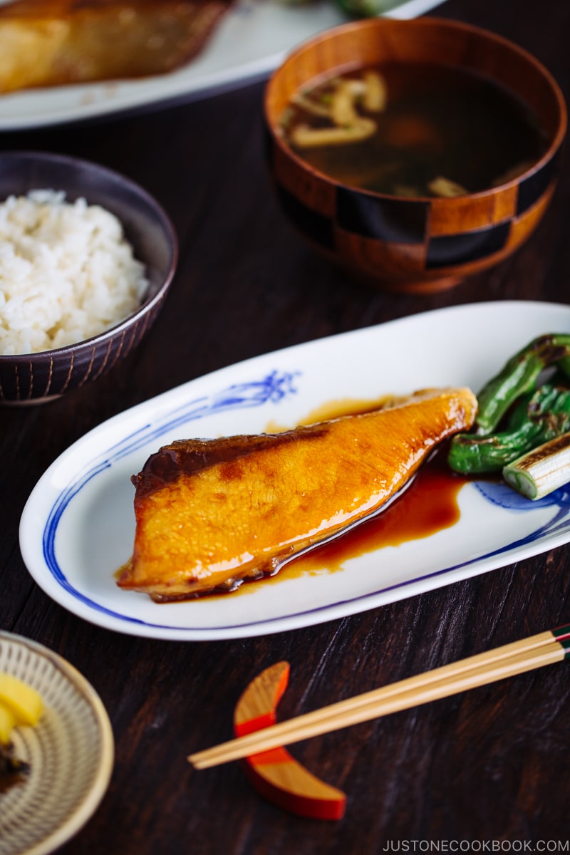 Yellowtail teriyaki served with blistered shishito peppers.