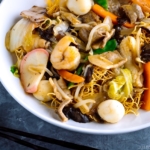 A white bowl containing Crispy Noodles with Seafood (Sara Udon).