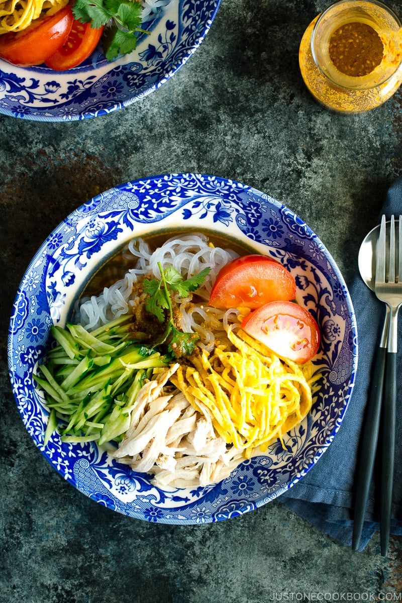 Un bol bleu contenant des nouilles shirataki froides et rafraîchissantes avec une vinaigrette au miel et au sésame.