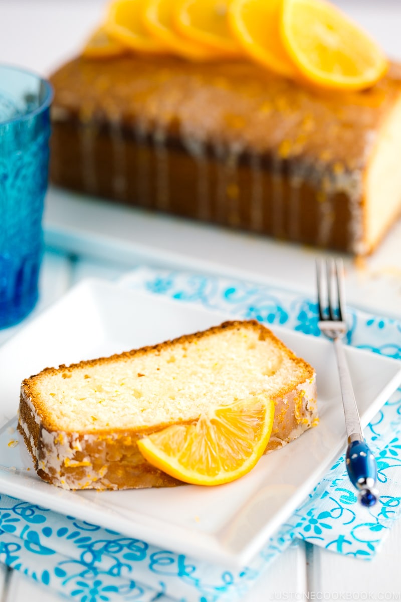 A slice of Meyer Lemon Pound Cake is on white plate.