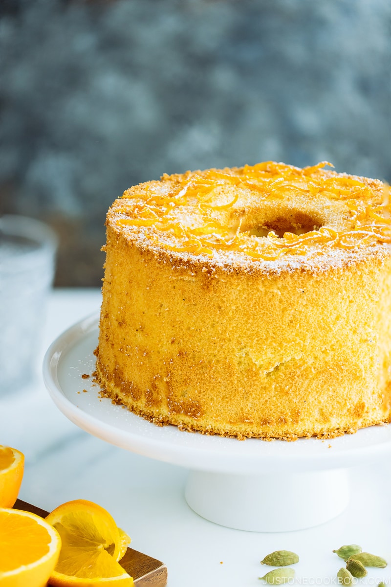 Orange chiffon cake served on a cake stand.