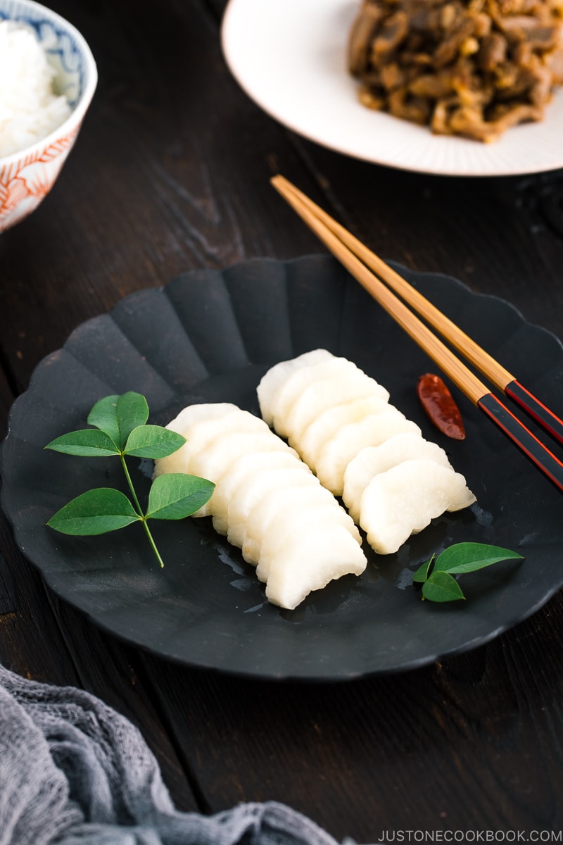 A black plate containing pickled daikon with shio koji.