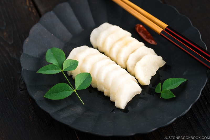 A black plate containing pickled daikon with shio koji.