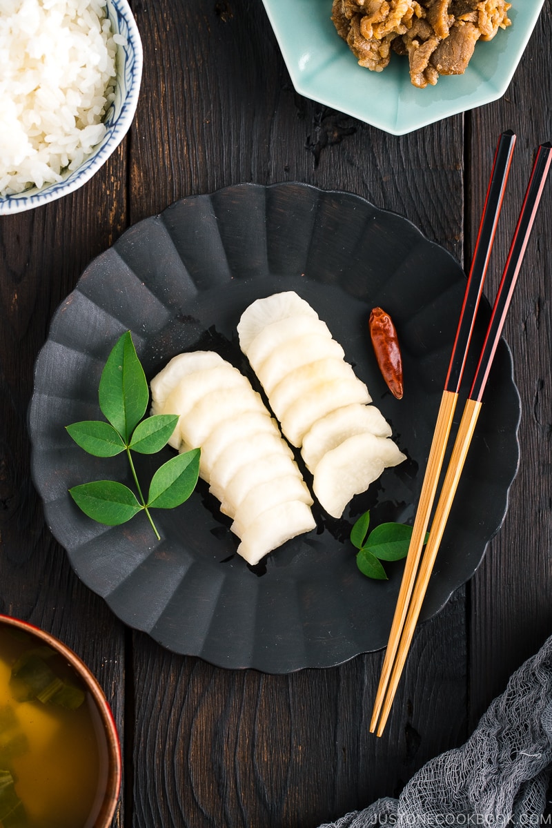 A black plate containing pickled daikon with shio koji.