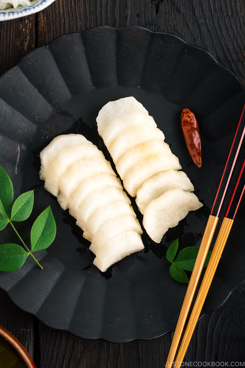 A black plate containing pickled daikon with shio koji.