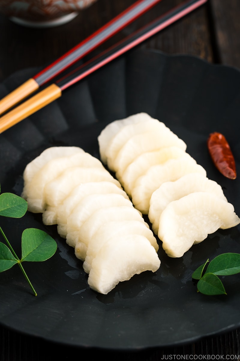 A black plate containing pickled daikon with shio koji.