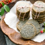 The wooden plate containing black sesame cookies.