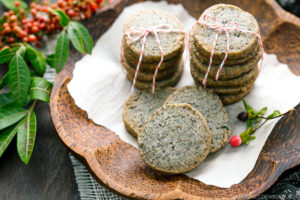 The wooden plate containing black sesame cookies.