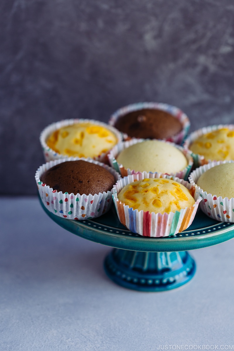 3 types of steamed cakes on a cake stand.