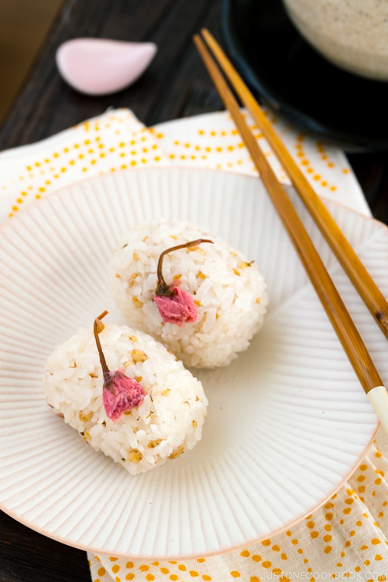 Cherry blossom rice balls on a white plate.