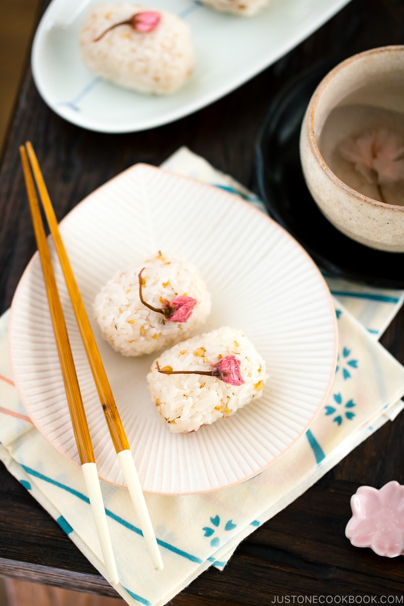 Cherry blossom rice balls on a white plate.