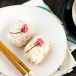 Cherry blossom rice balls on a white plate.