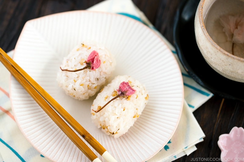 Cherry blossom rice balls on a white plate.