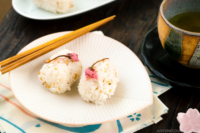 Cherry blossom rice balls on a white plate.