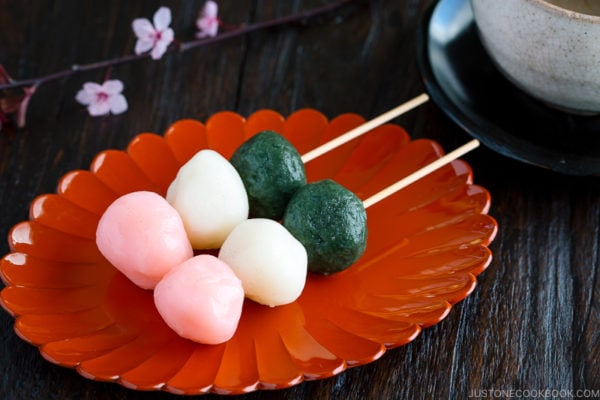 A lacquer plate containing Hanami Dango on a skewer.