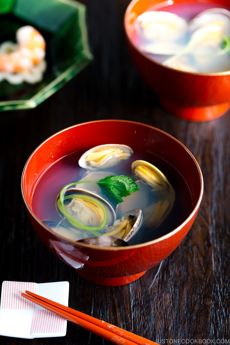 Japanese clam clear soup in a red bowl.