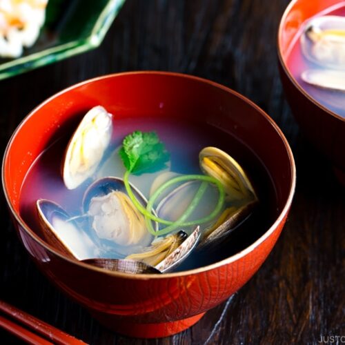 Japanese clam clear soup in a red bowl.