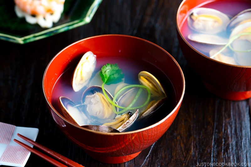 Japanese clam clear soup in a red bowl.