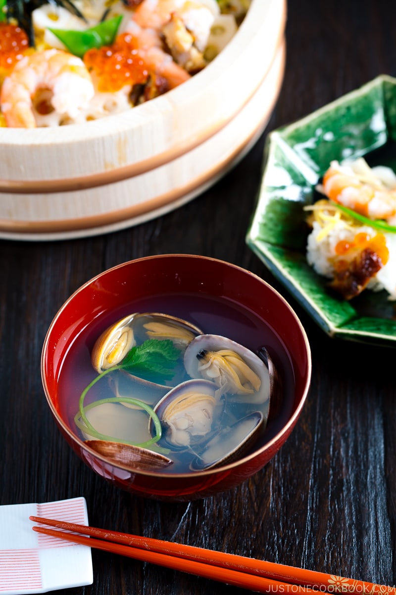 Japanese clam clear soup in a red bowl.