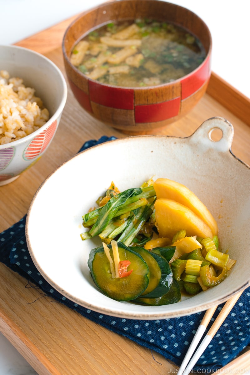 4 kinds of soy sauce pickles are served in a white bowl, along with steamed rice and miso soup.