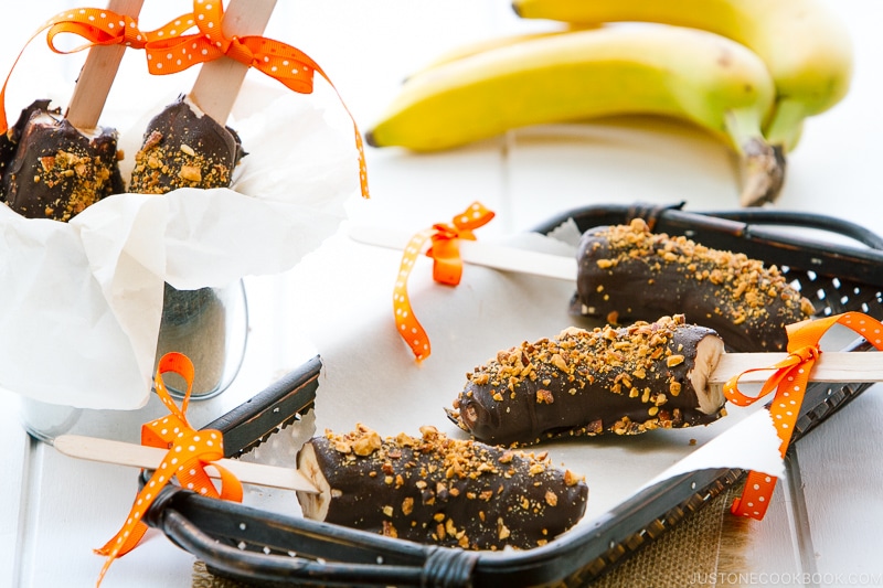 Frozen chocolate bananas sprinkled with almonds.