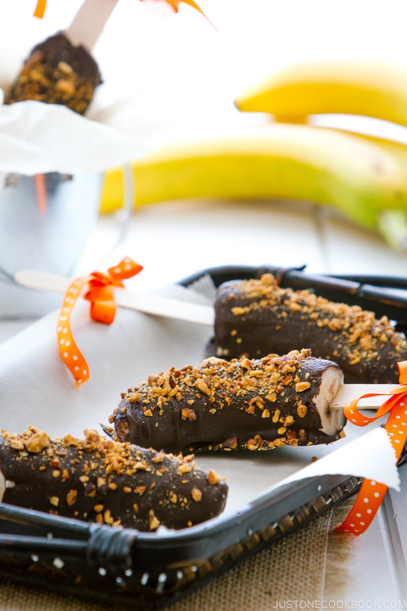 Frozen chocolate bananas sprinkled with almonds.