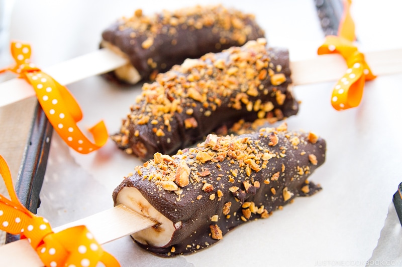 Frozen chocolate bananas sprinkled with almonds.