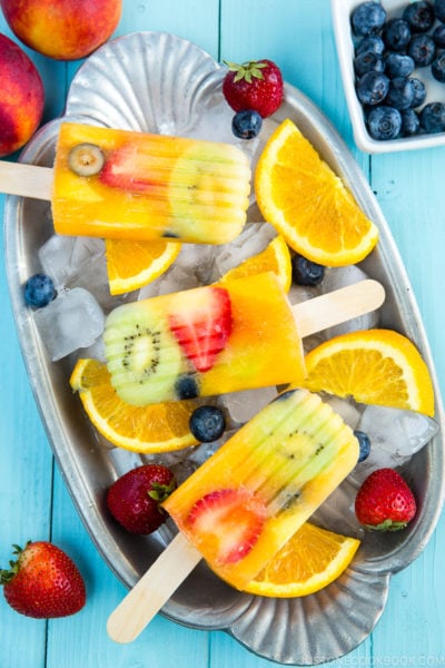 Homemade fruit popsicles on ice cubes.