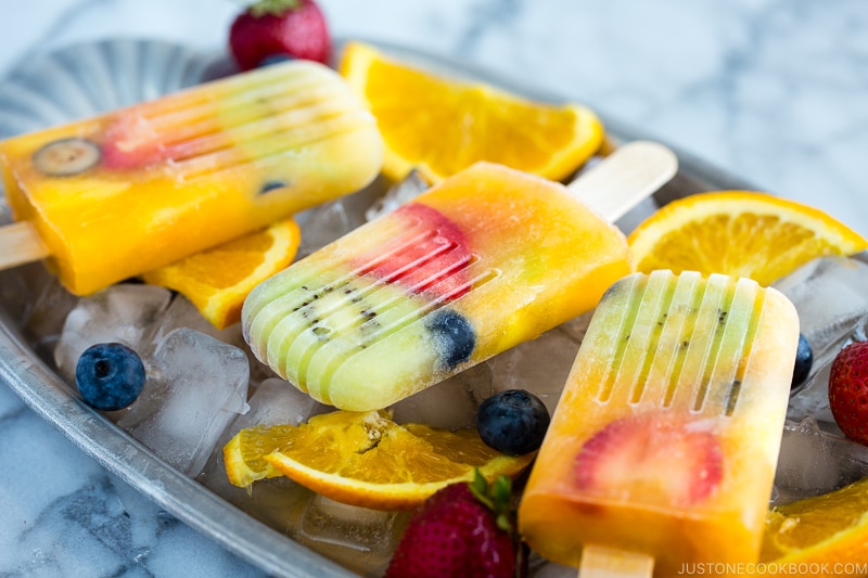 Homemade fruit popsicles on ice cubes.