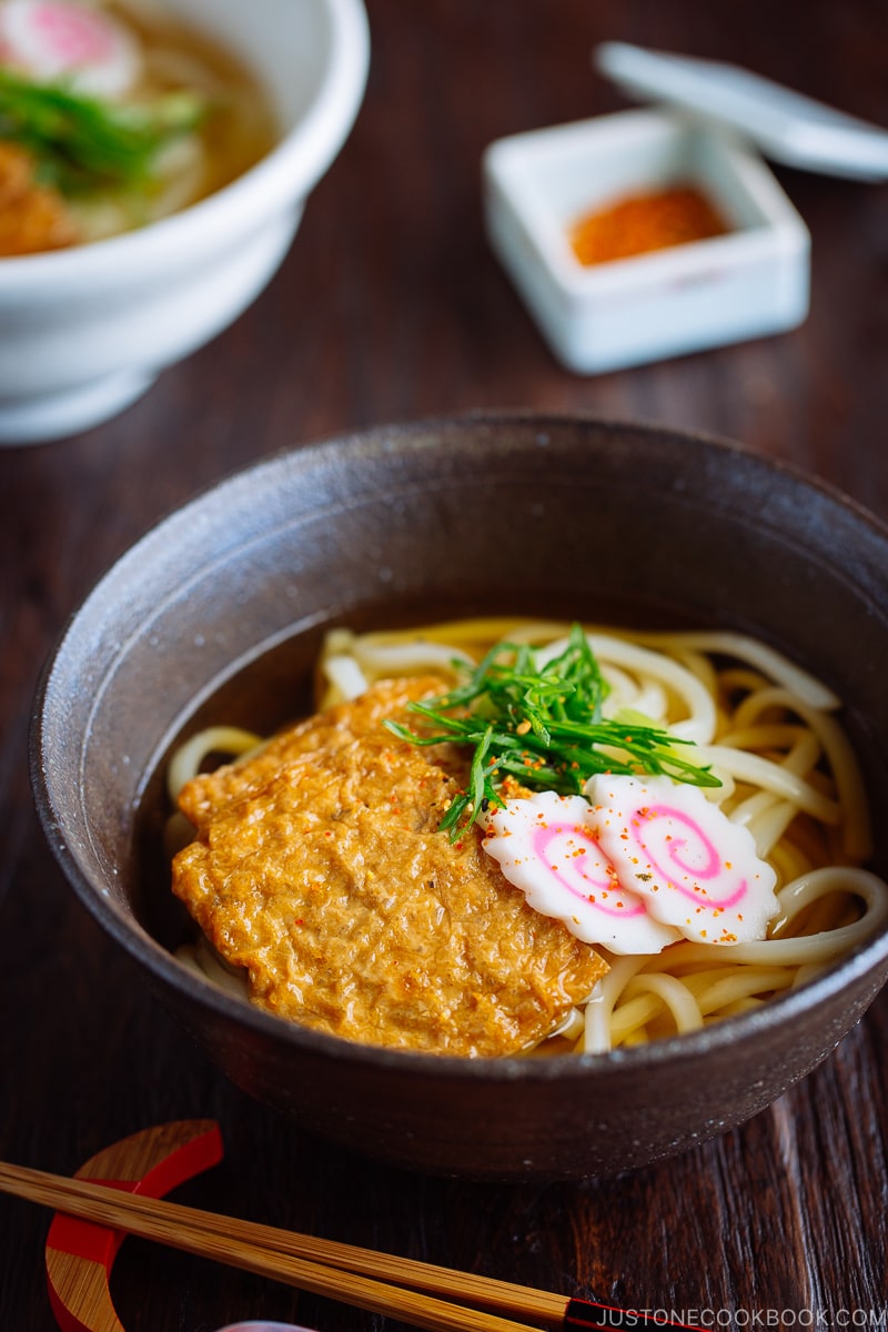 A dark bowl containing Kitsune Udon Noodle Soup.